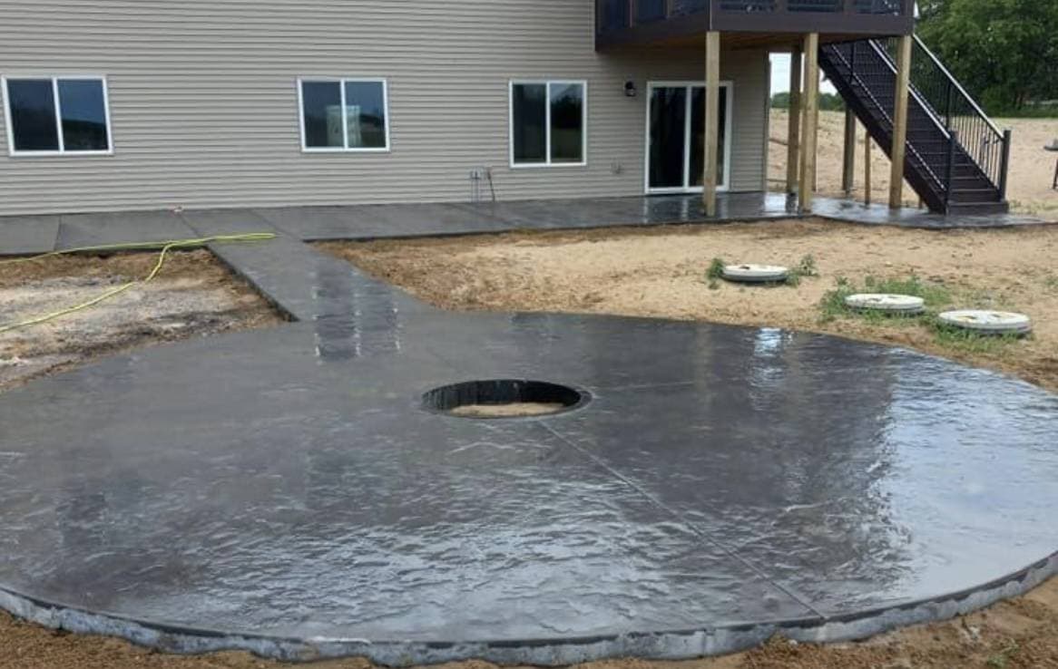 picture of a concrete circular patio in the back of the house